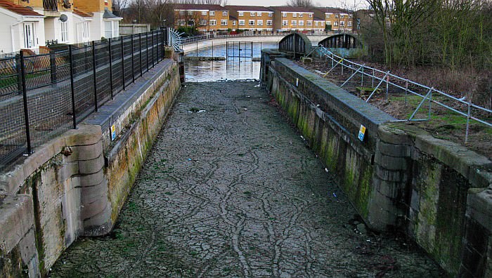 On the other side of the concrete flood barrier one can see the Royal Arsenal cnal's entrance lock. The inward seaward gates have long gone, but the top gates and the swing bridge survive